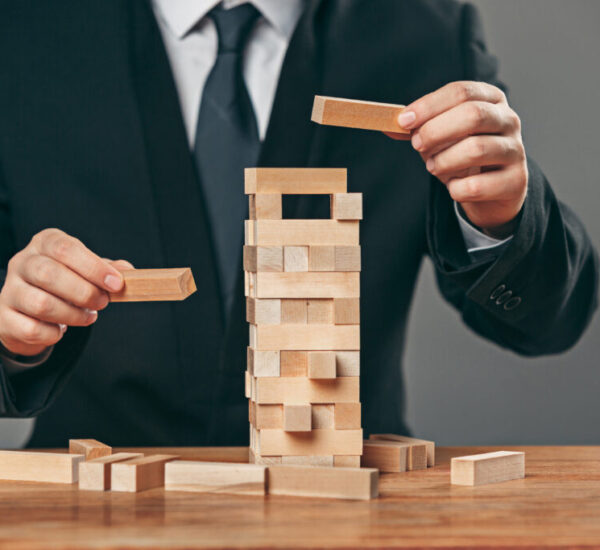 Man and wooden cubes on table. Management concept